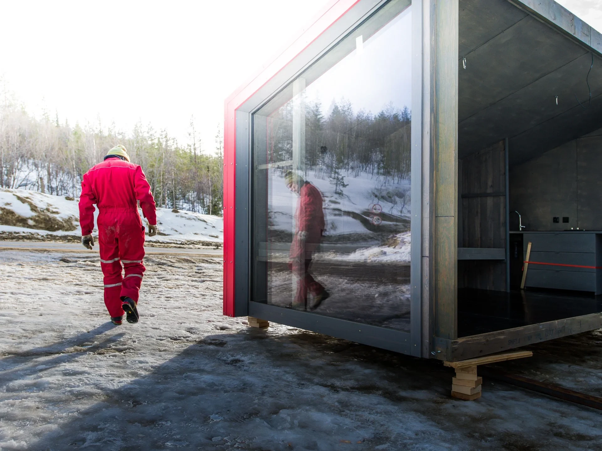 Worker in red overalls beside the module