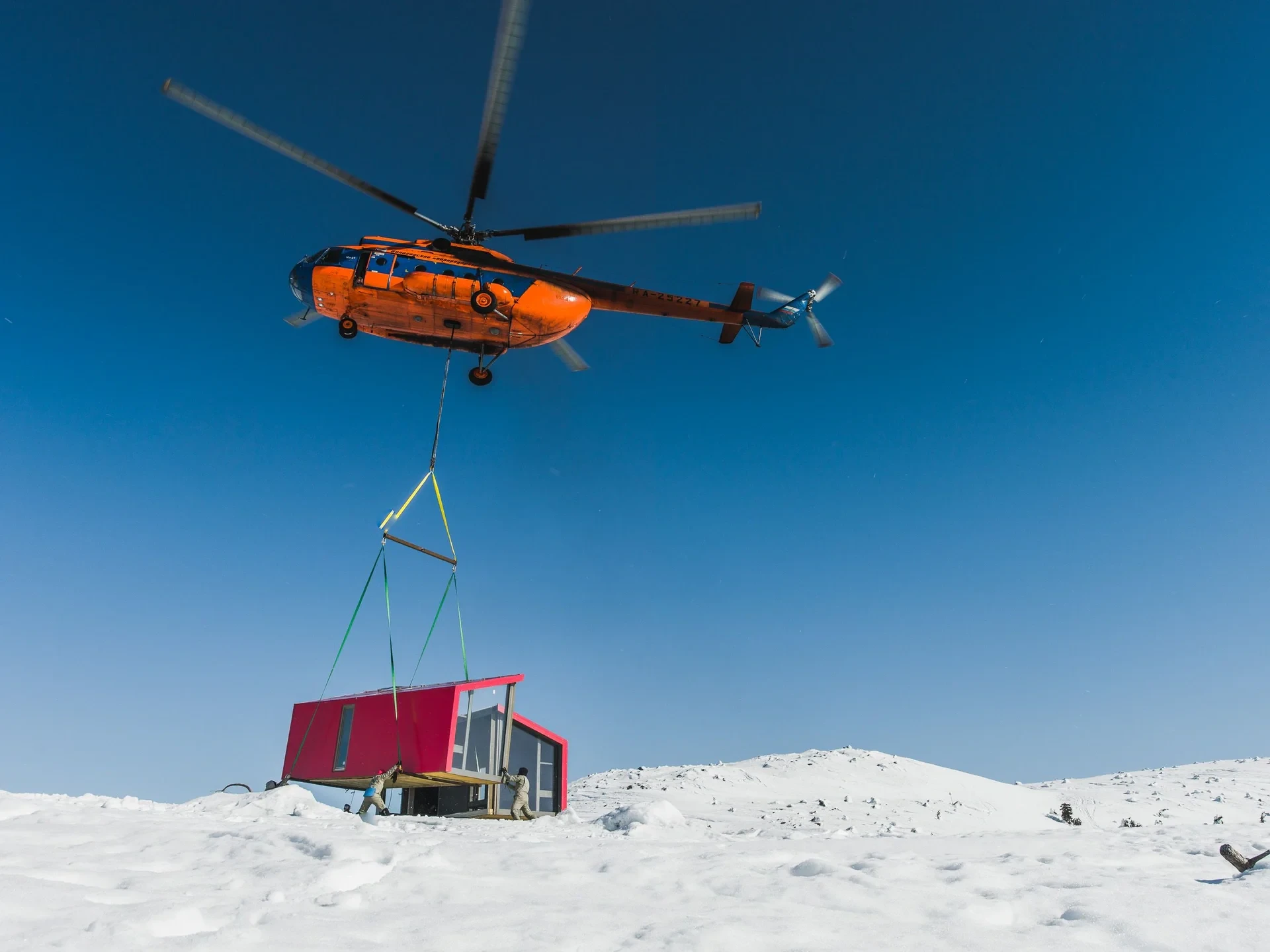 Helicopter lowering module onto snowy site