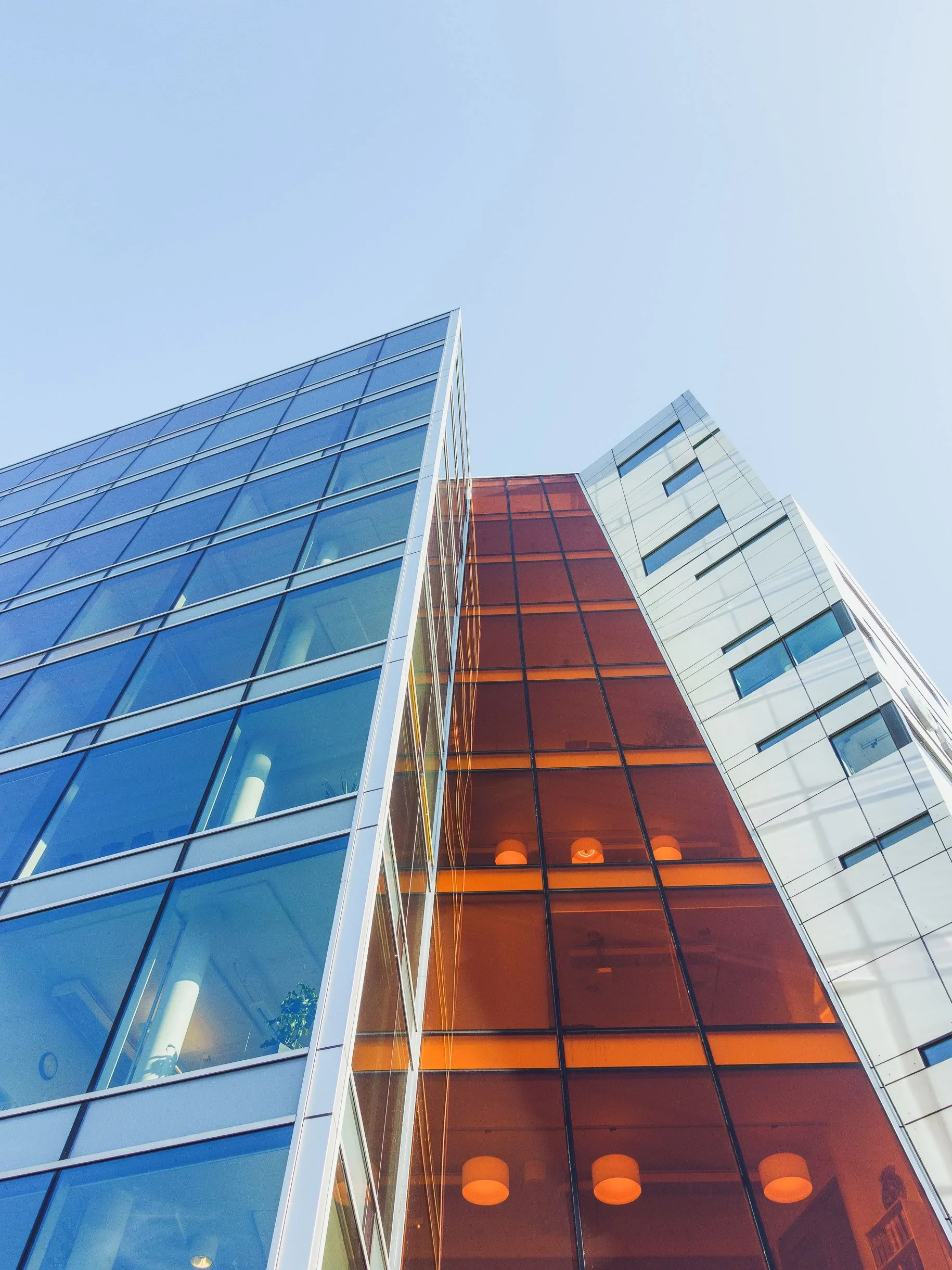 Glass tower with orange facade from below