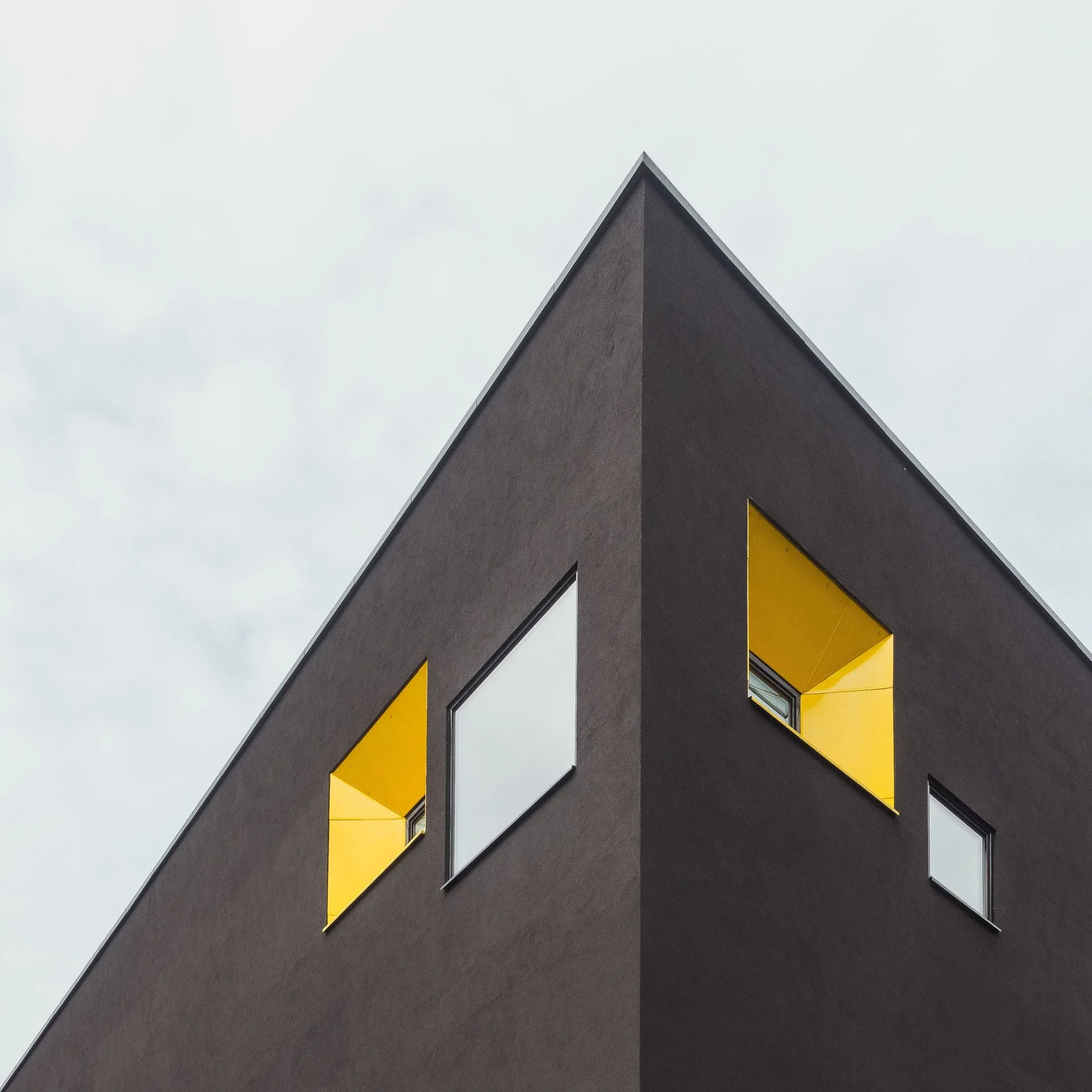 Dark building corner with yellow window reveals