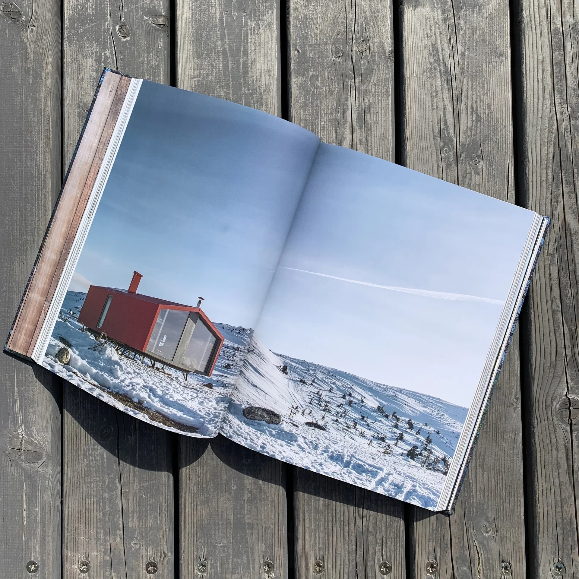 Book spread of red cabin in snow