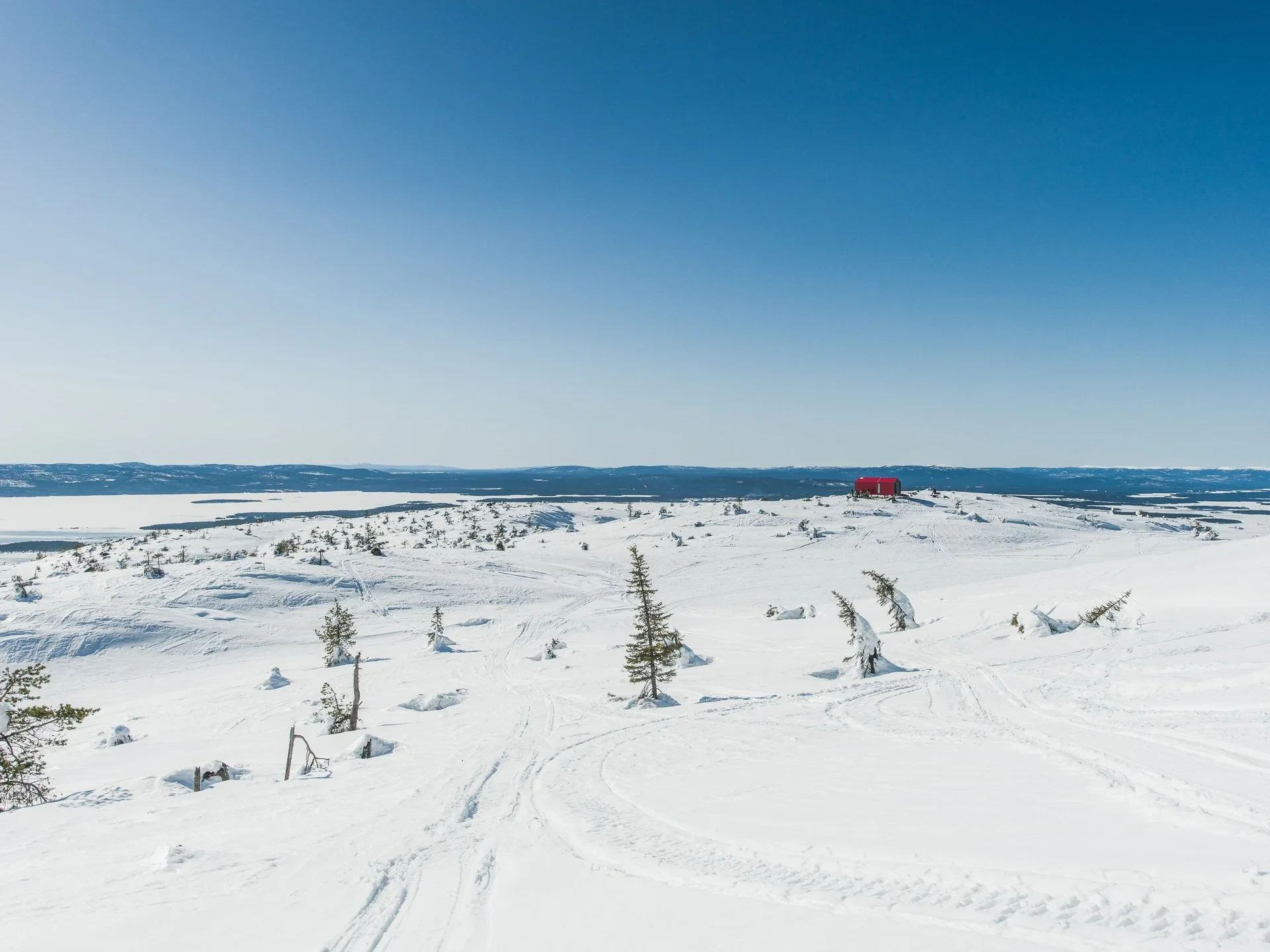Red cabin on vast snowy plateau