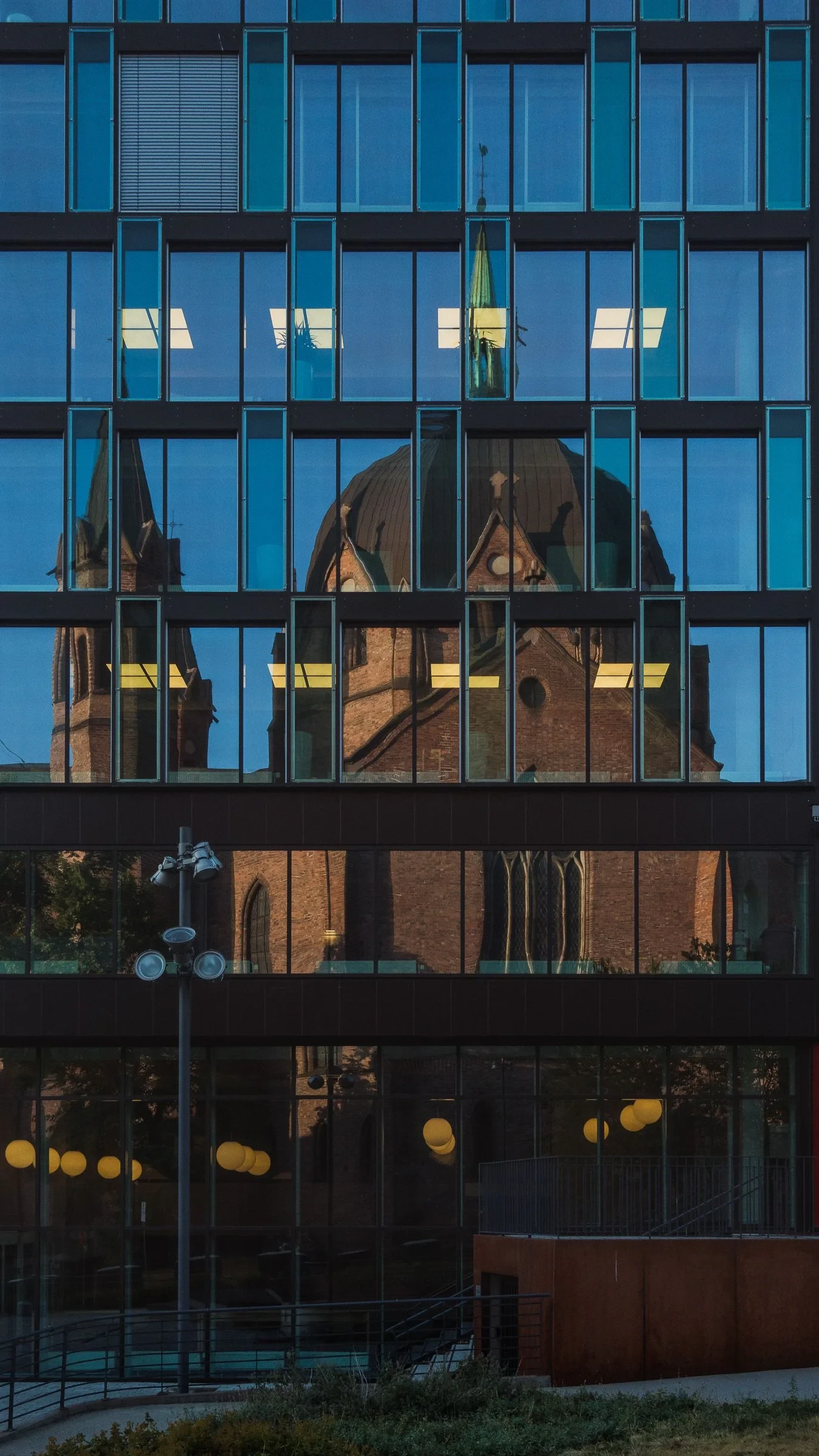 Brick church reflected in a glass facade