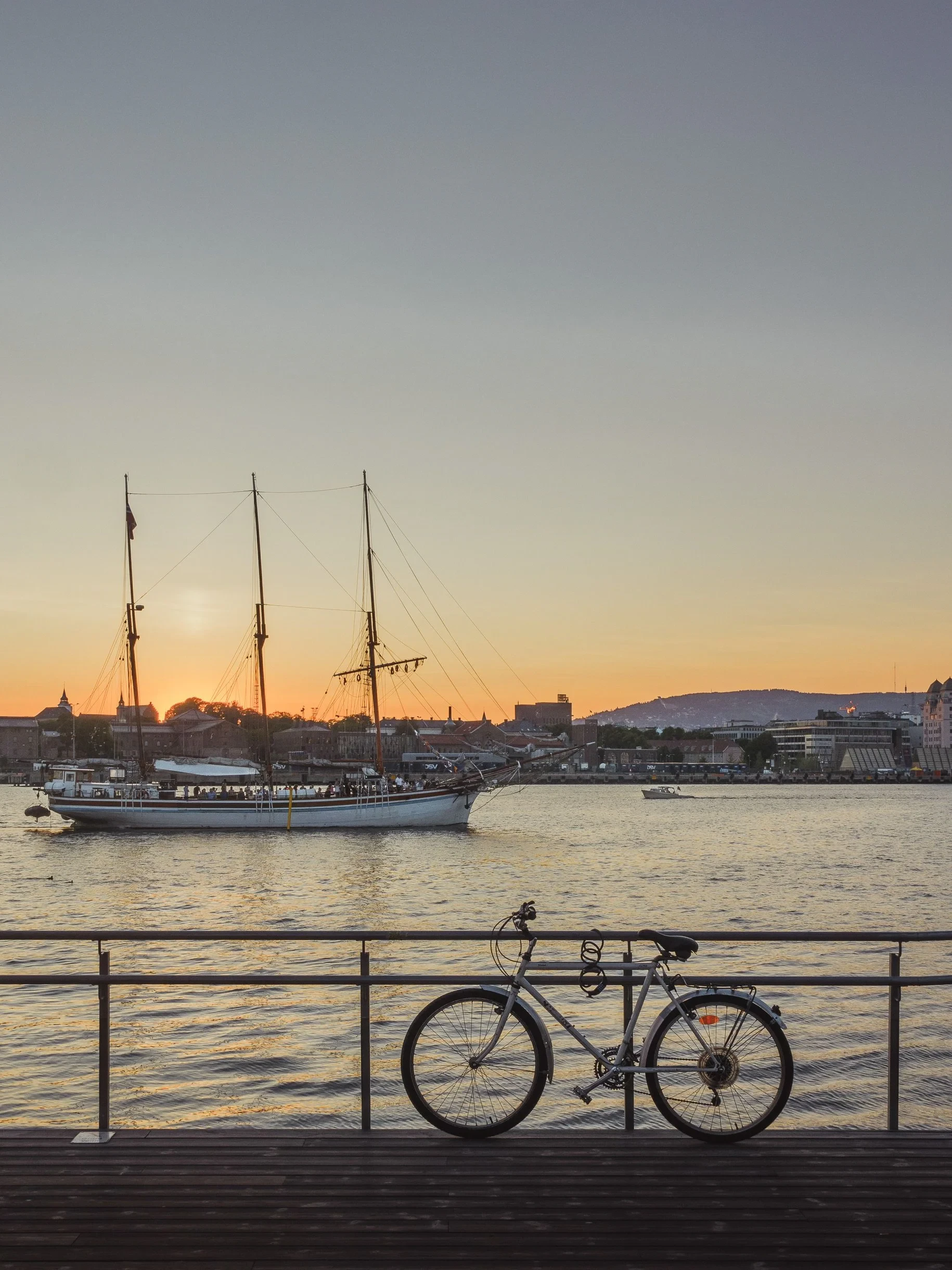 Bicycle and tall ship at the harbour at sunset