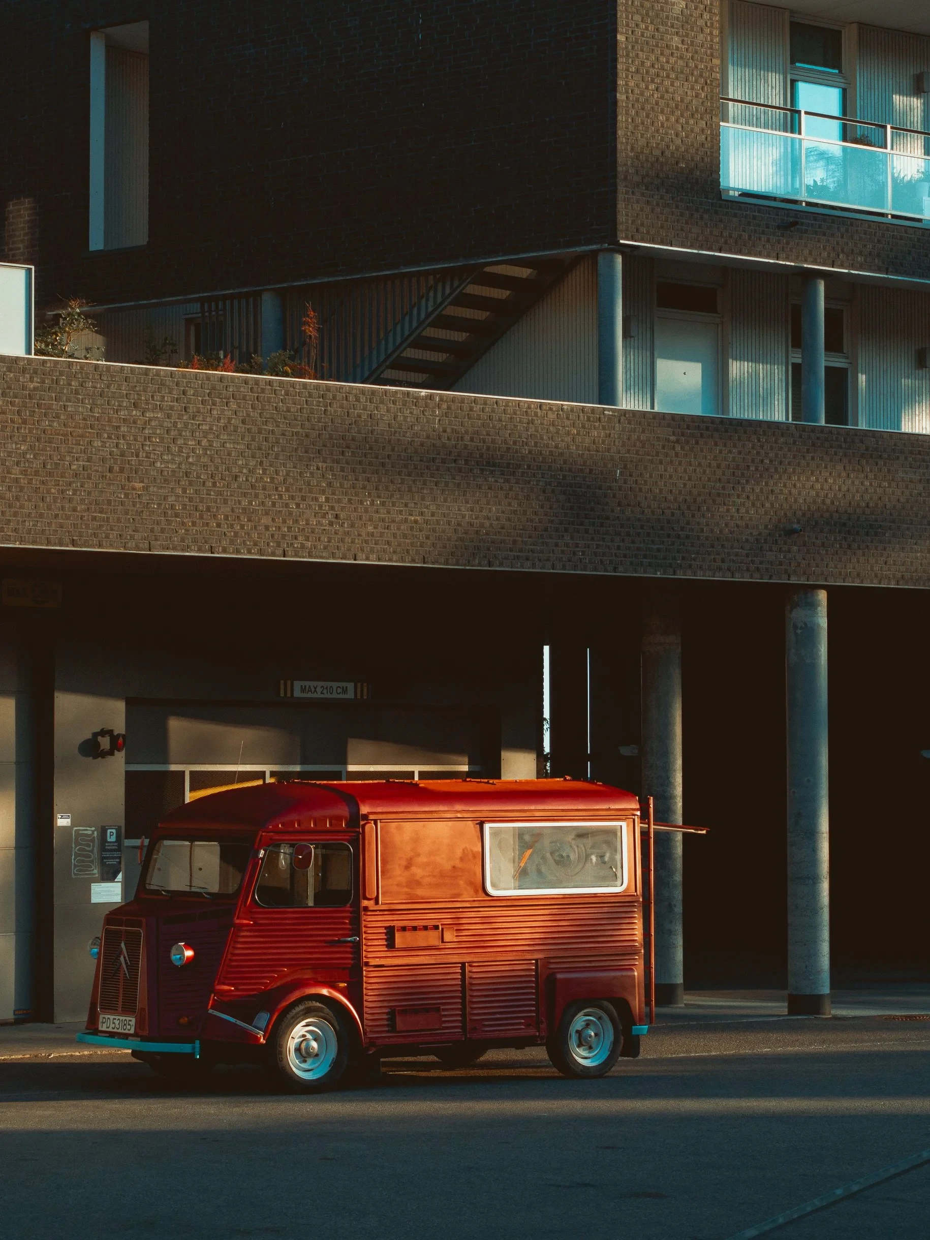 Vintage red Citroen van under a building