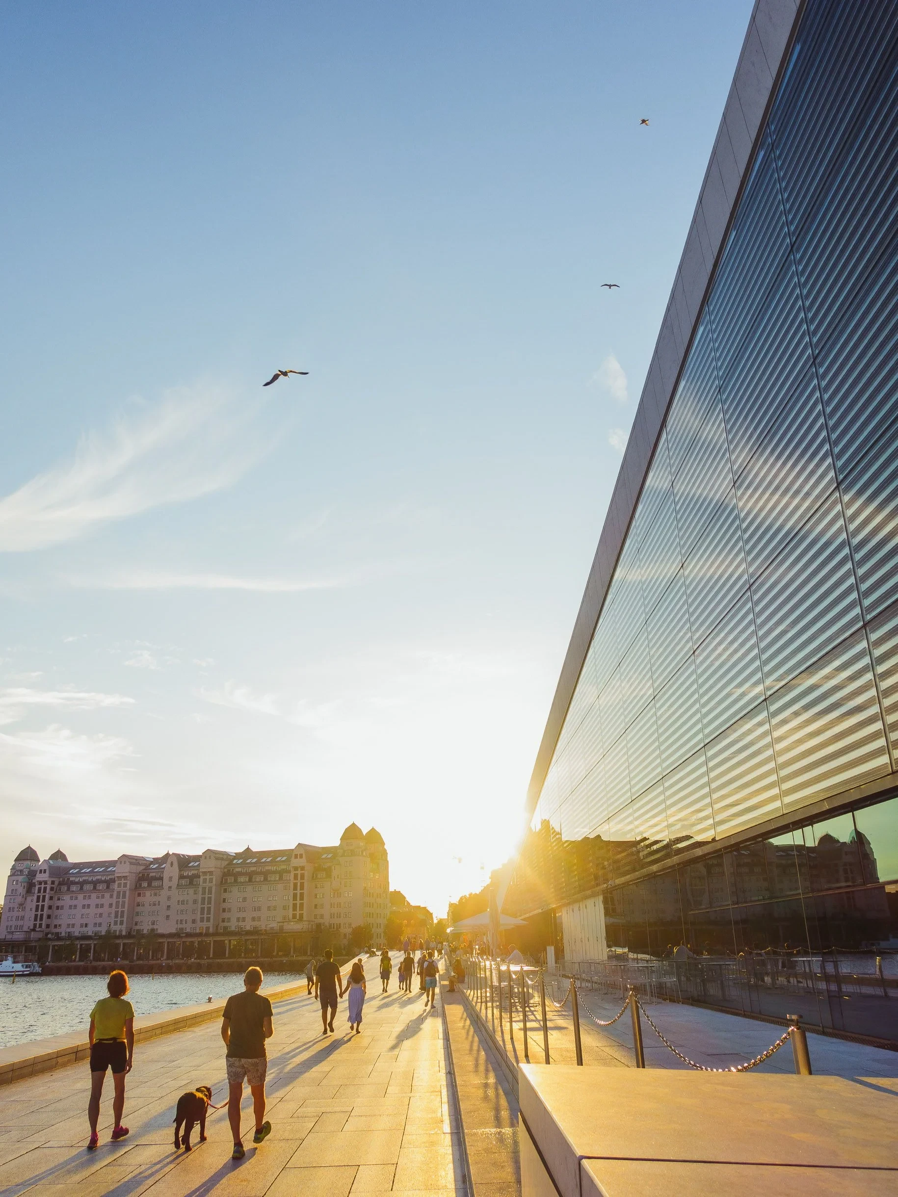 People walking the Opera House promenade at sunset