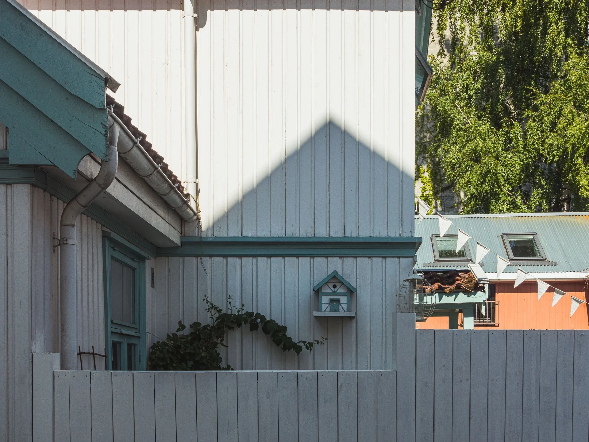 Pale wooden houses with a birdhouse and bunting