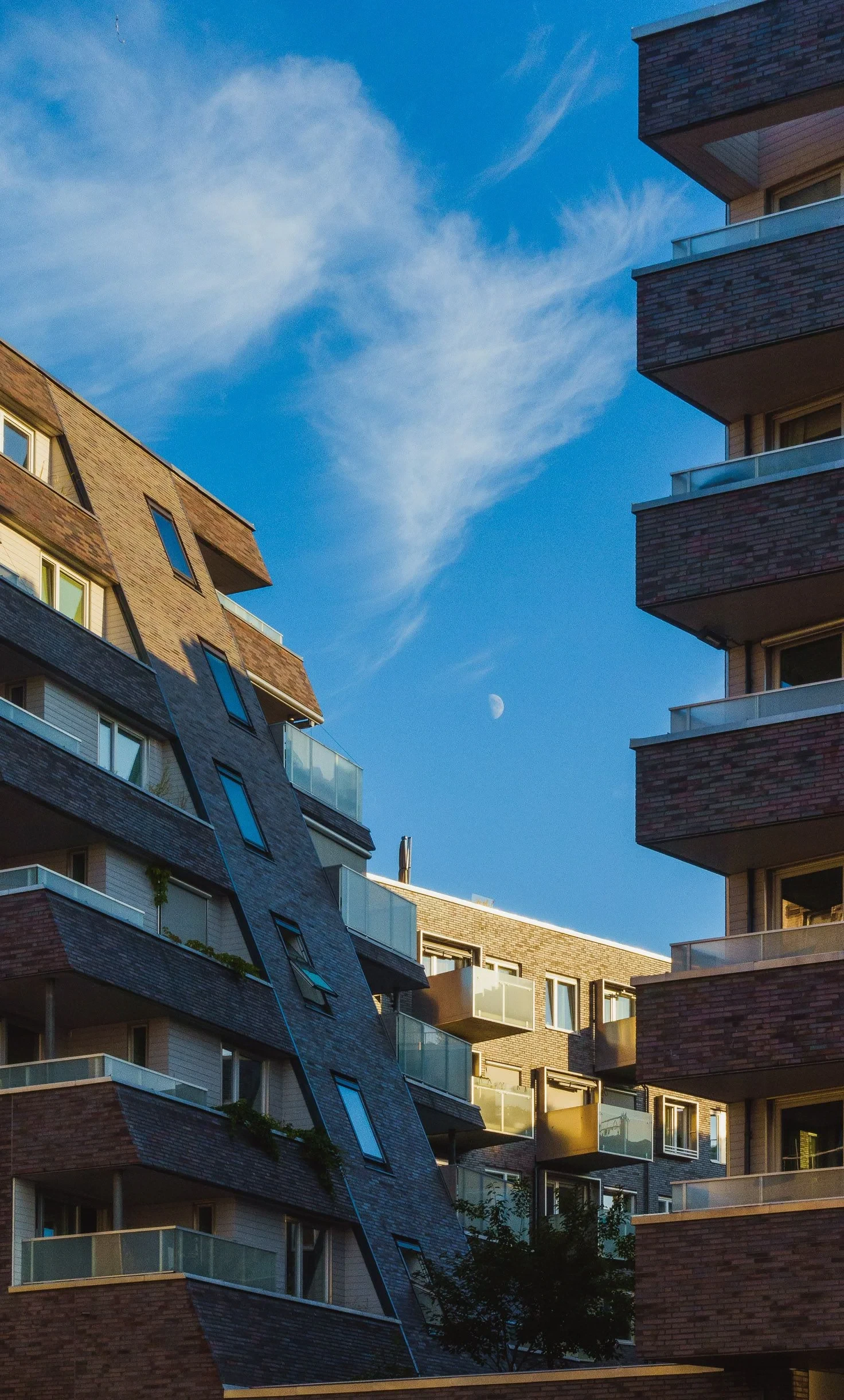 Brick apartment buildings with balconies and moon